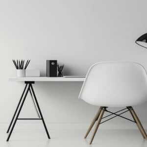 Poste de travail minimaliste avec un bureau blanc et une chaise design scandinave, parfait pour un bureau à domicile ou un espace de travail individuel.