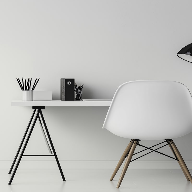 Poste de travail minimaliste avec un bureau blanc et une chaise design scandinave, parfait pour un bureau à domicile ou un espace de travail individuel.