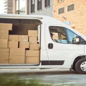 Véhicule utilitaire pour la livraison de mobilier de bureau, rempli de cartons destinés à aménager des espaces de travail professionnels.